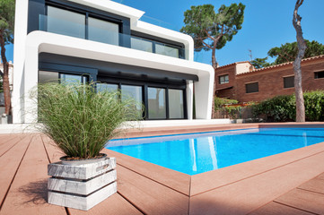 Luxurious villa with swimming pool at dusk. External view of a contemporary house. New technologies in construction.