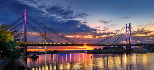 Belgrade panorama New Railway and Ada bridges Sava River after sunset, colorful lights reflection on water