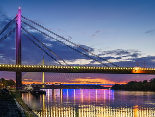 Belgrade panorama New Railway and Ada bridges Sava River after sunset, colorful lights reflection on water