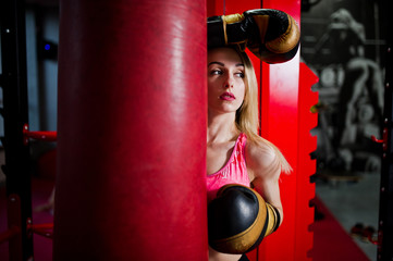 Sexy sport blonde girl punching bag. Fit woman boxing.