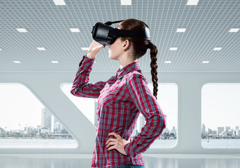 Girl in checked shirt wearing VR glasses experiencing another re