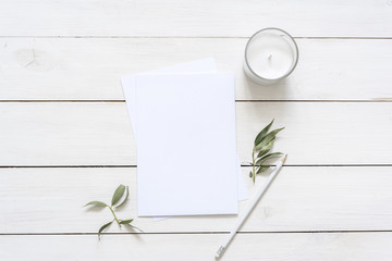 Modern flat lay with card blank space, stationary, candle, leaves, white pencil. Ready for you to insert your text, invitation, wedding or logo. Best for social media, backgrounds, blogs