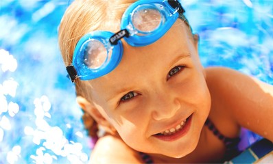 Beautiful little girl swimming at the pool