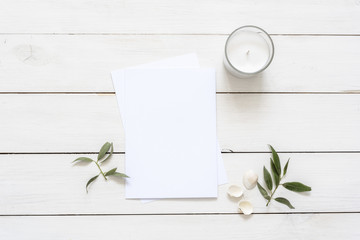 Stylish flat lay with card blank space, stationary, candle, seashells, leaves. Ready to insert your text, invitation, wedding or logo. Best for social media, backgrounds, headers, blogs, wedding
