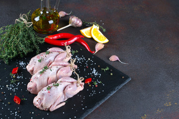 Fresh  raw meat quails ready for cooking on the  slate board - obrazy, fototapety, plakaty