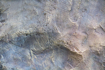 Texture of a multi-colored wall with plaster, cracks, rubs, stains and granularity.