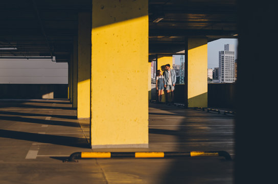 Couple holding hands standing near parking wall