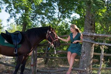 Young beautiful girl with a horse on nature