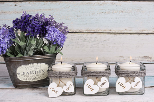 Fototapeta Flores de lavanda en macetero vintage y velas encendidas.