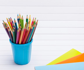 Fototapeta premium Color pencils in a pencil case and notebooks isolated on white background