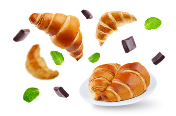 Flying croissants with chocolate and mint leaves isolated