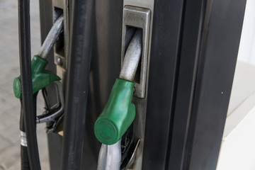 Close up on dirty fuel nozzle in oil dispenser with gasoline and diesel in service gas station....