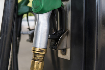 Close up on dirty fuel nozzle in oil dispenser with gasoline and diesel in service gas station....