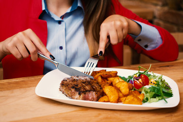 a business girl eats a steak at a restaurant