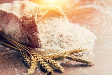 Wheat ears and flour on desk
