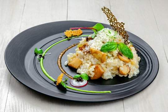 Gourmet Italian risotto cooked in a vegetable broth with porcini mushrooms and parmesan cheese served on an expensive exclusive plate.