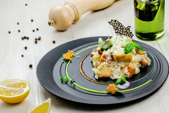 Creamy baked mushroom risotto from Italy on an exclusive beautiful plate. Vegetarian Italian meal made of rice, vegetable broth, porcini mushrooms and parmesan cheese.