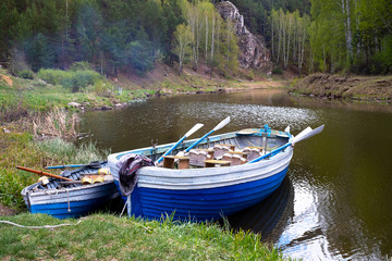 Obraz premium two wooden boats with oars on the bank of the forest river, forest