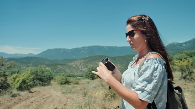Young traveler woman taking photo of amazing landscape using camera outdoor