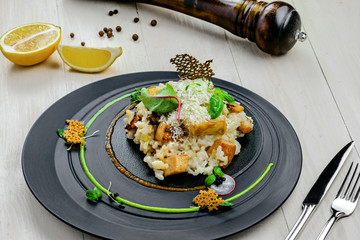 Classic Italian risotto cooked in a vegetable broth with porcini mushrooms and parmesan on a wooden...