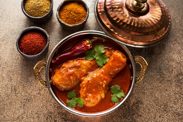 Indian dish Spicy Chicken legs Curry and spices in bowls.
