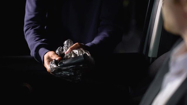 Young man buying illegal weapons for self-defense, illicit gun trafficking
