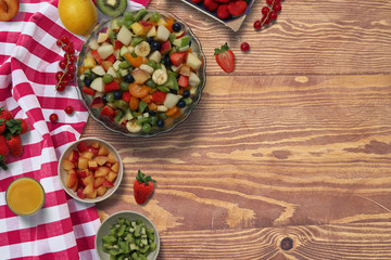 fruit salad setting from above with bowls and fruits on a table
