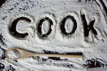 Cook word written on the flour on the table