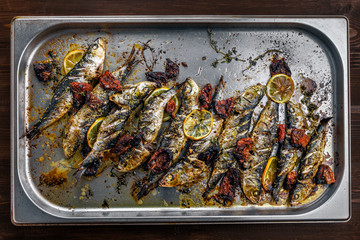 Delicious baked sardines on a tray. Healthy meal made of fresh fish. Directly above top view shot.