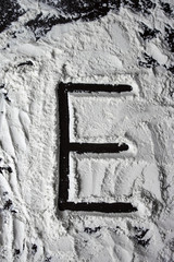 E letter written on the flour on the table