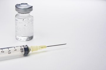A syringe and bottle of medication on white background