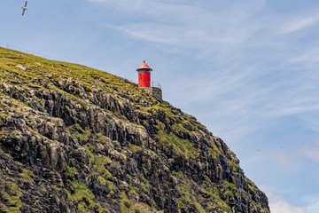 Fototapeta na wymiar lighthouse on the outermost edge, on the faroe islands