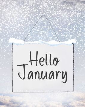 Hello January text on white plate board banner with cold snow flakes qoute