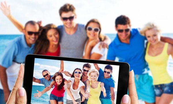 Happy friends making selfie on beach on summer day