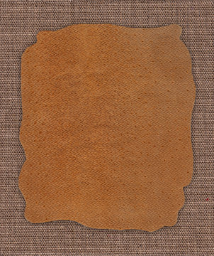 Piece of leather on the fabric linen textile texture