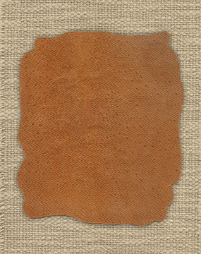 Piece of leather on the fabric linen textile texture