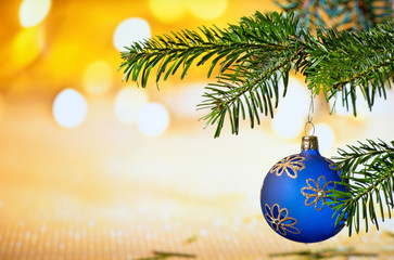 Fototapeta na wymiar Blue Christmas Ball with Christmas Twig on the Unfocused Background