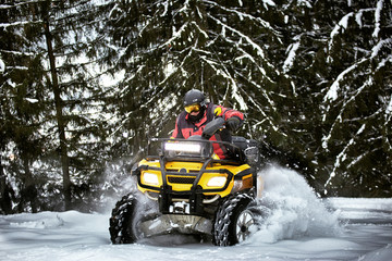 Winter race on an ATV on snow in the forest. © Bondariev Volodymyr.