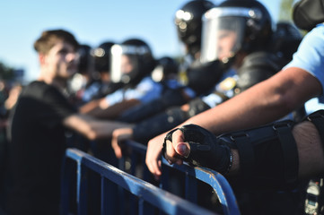  Security staff hands on a protection fence during a riot