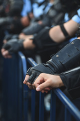  Security staff hands on a protection fence during a riot