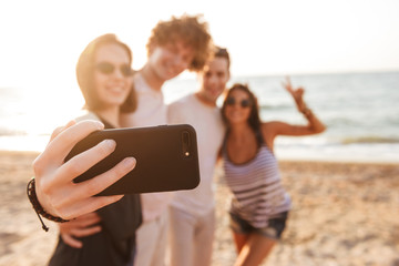 Happy friends loving couples make selfie by mobile phone.