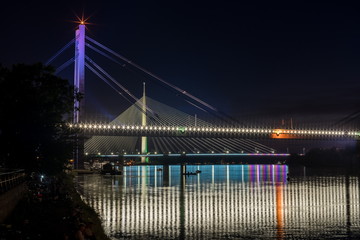 New Railway and Ada Bridges Sava River Belgrade by Night With Fishermen and Boats and city lights water 