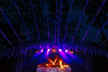 Free stage with purple and orange spot lights decorated with nature flowers. Wedding scene