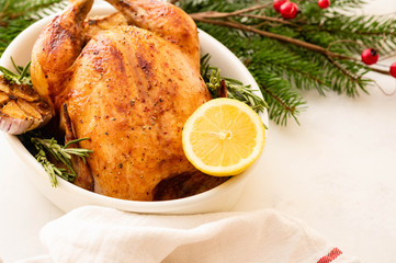 Fototapeta na wymiar Roast chicken with lemons, garlic and rosemary for Christmas. Christmas concept.