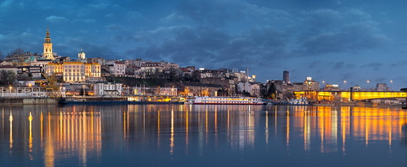 Old Belgrade panorama by night with Cathedral and Branko's bridge on Sava river and city lights water reflections - obrazy, fototapety, plakaty