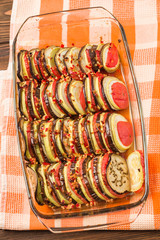 Ratatouille close up macro photography with fresh cooked vegetarian meal on brown wooden background.