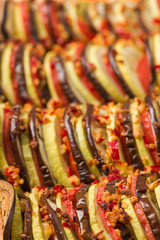 Ratatouille close up macro photography with fresh cooked vegetarian meal on brown wooden background.