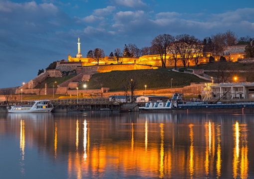 Old Belgrade Kalemegdan fortress, Victor monument by night on Sava river and city lights water reflections