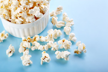 Popcorn on a bright blue background. Film. Fast food. Corn