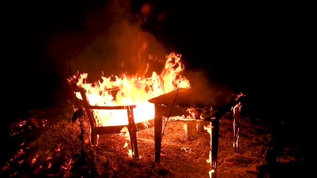 Table and bench burning in a huge fire. Hot seat, isn't it?